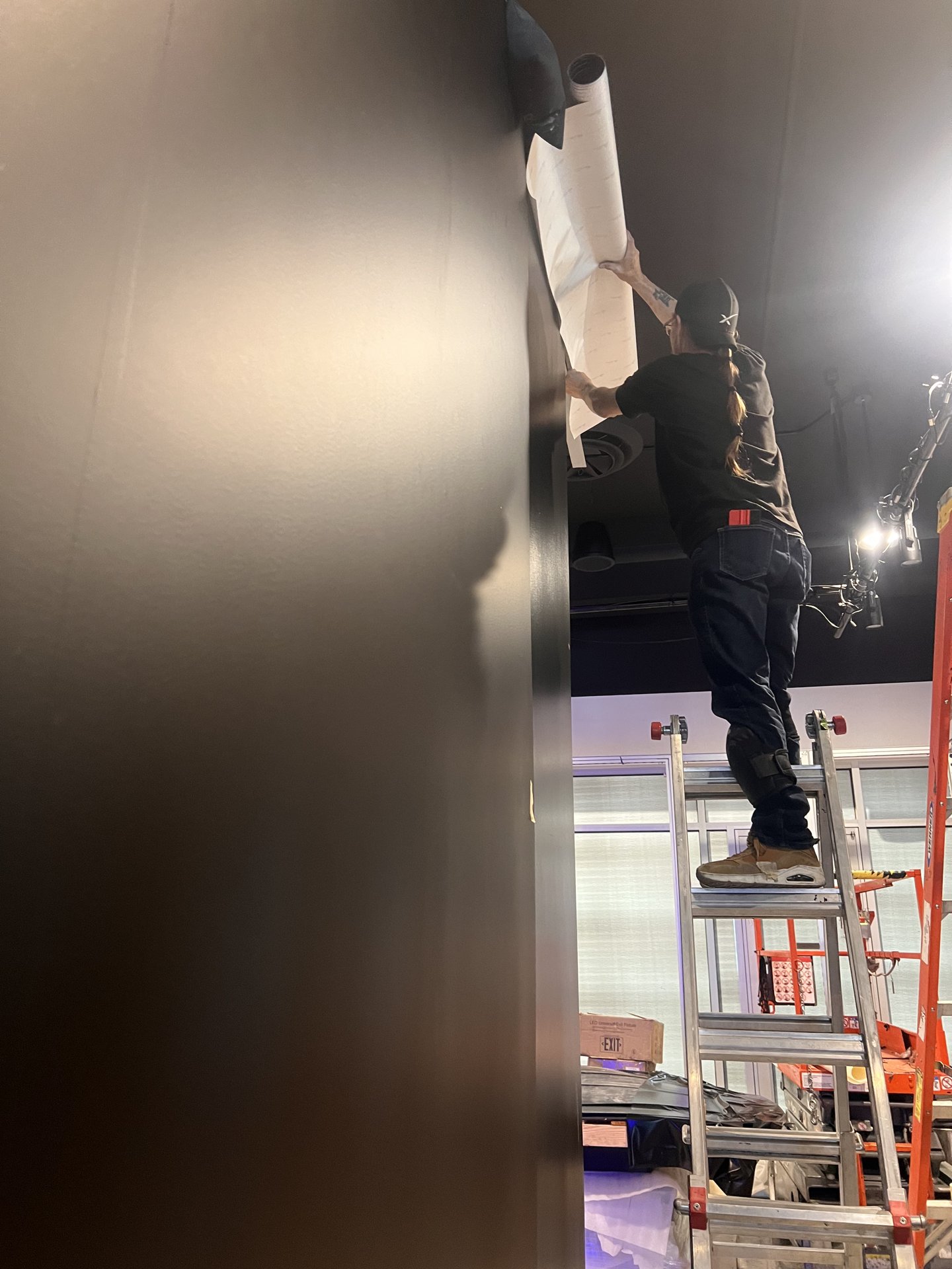 Architectural wall wrap install with ceiling-height ladder work