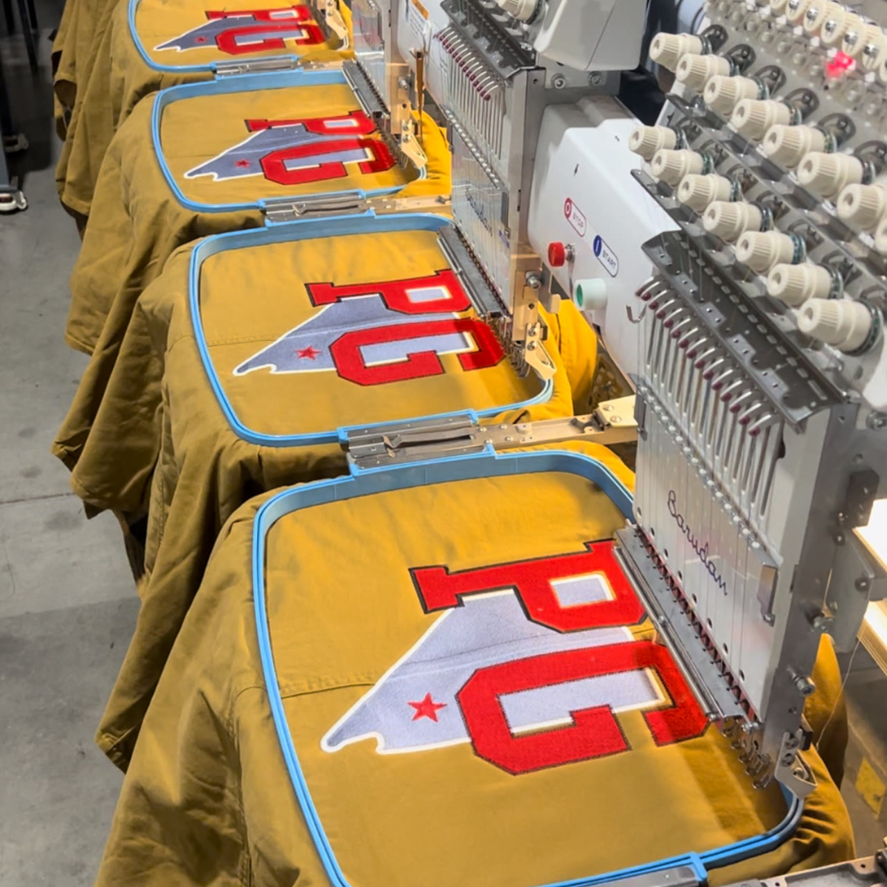 Multi-head run of red & white twill letterman applique on workshirts