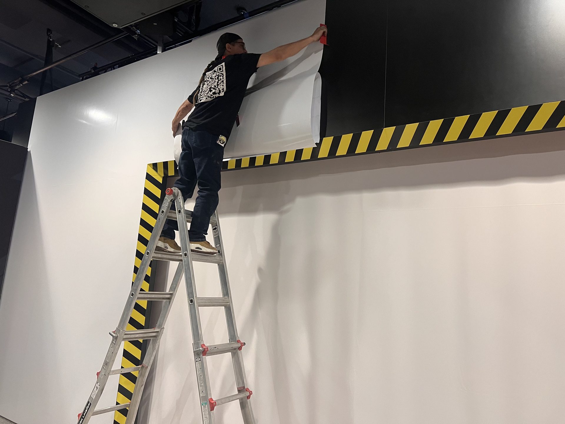 Large-format wall graphic application — show-floor finish work