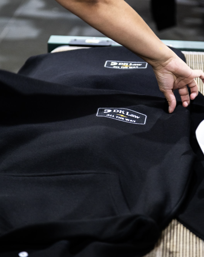Freshly screen printed DK Law shirts moving through finishing on the production floor