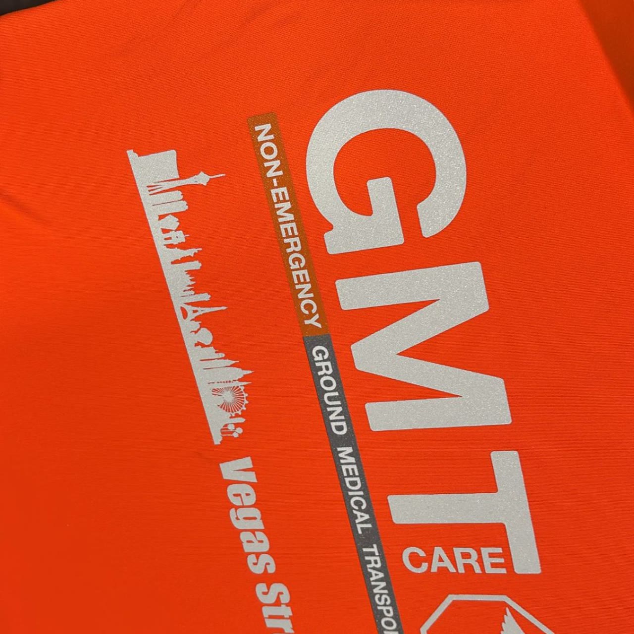 GMT Care Ground Medical Transportation Vegas Strong screen-printed safety orange staff shirt