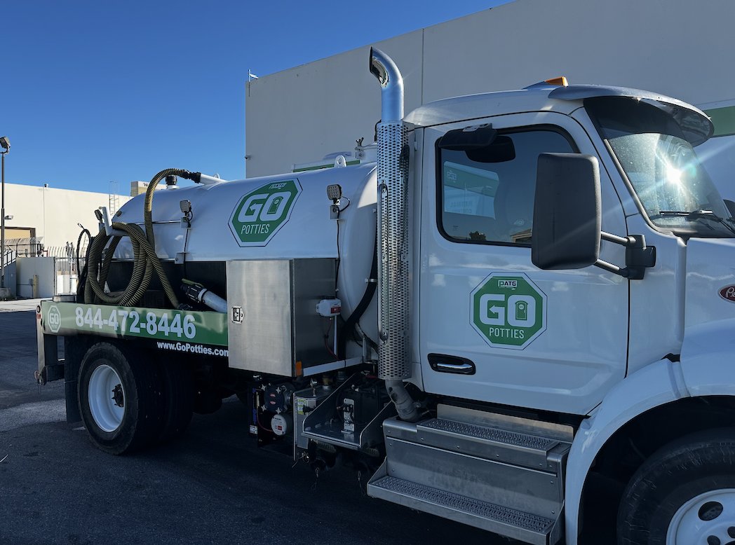 Vacuum-truck partial wrap — cab logos + tank-side branding