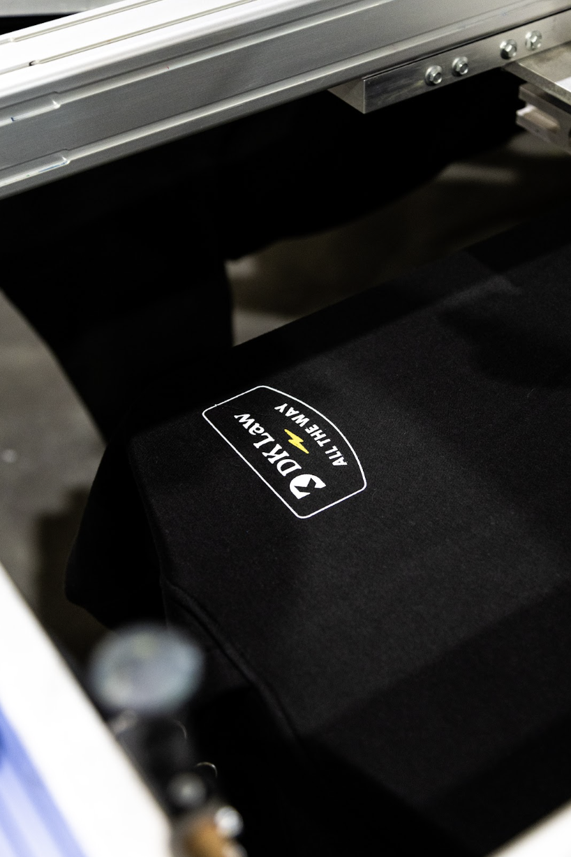 DK Law logo screen printed on black apparel during an in-shop production run in Las Vegas