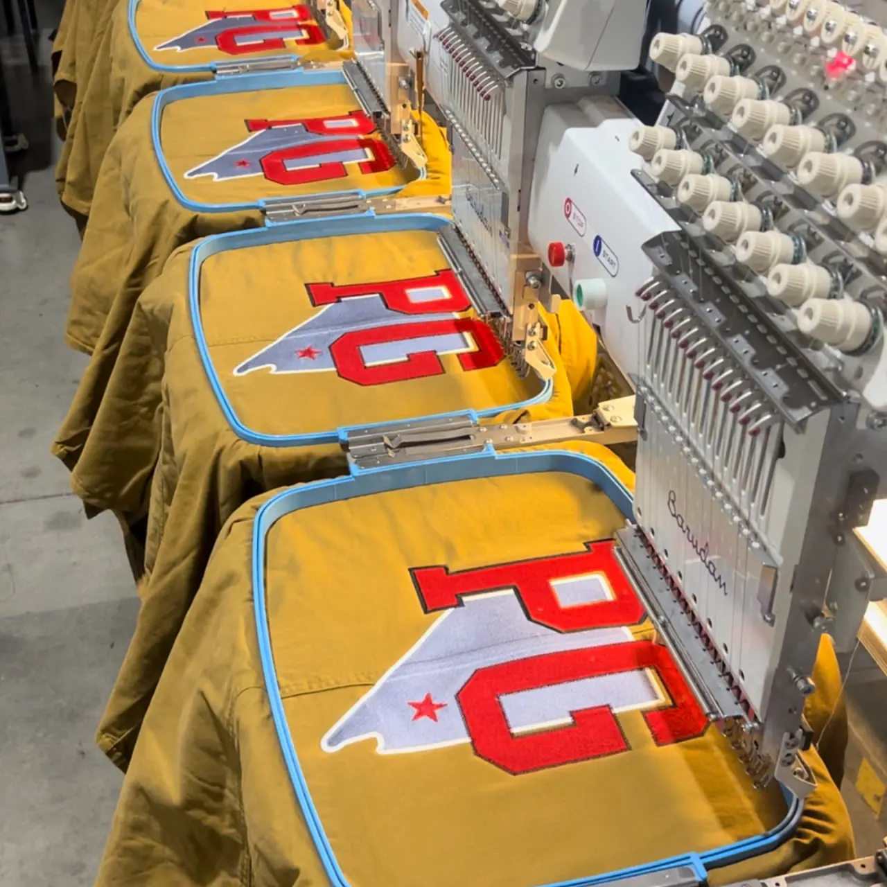 Multi-head run of red & white twill letterman applique on workshirts