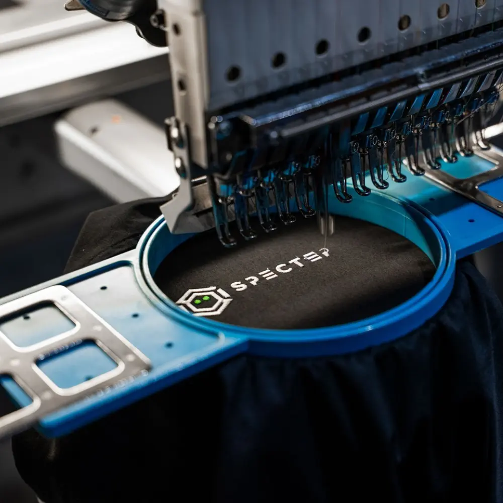 Embroidery machine stitching a branded polo